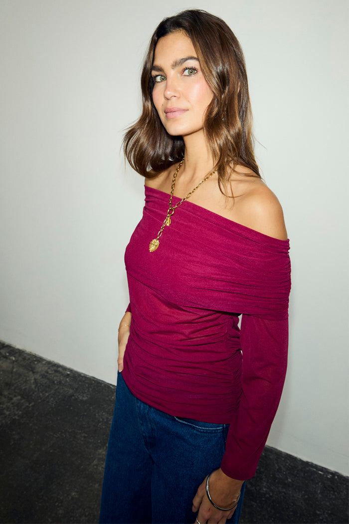 Burgundy Diaz Top with an off-the-shoulder mesh design and ruching, styled with denim jeans.