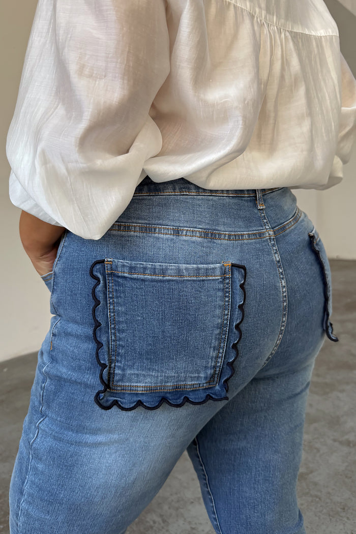 Blue Denim Flare Scallop Jean highlighting the navy scalloped pocket detail on a curve model.