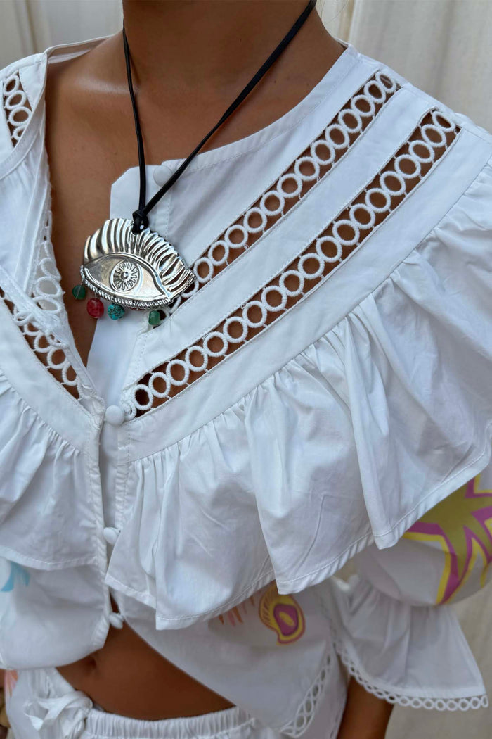 White cotton Dreamer Willa Top featuring a ruffled cut-out neckline and iconic sun and star motifs.