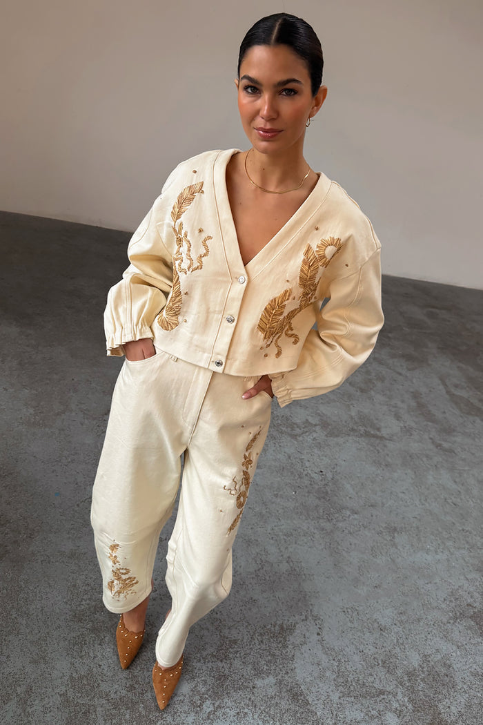 Ecru Raffia Palma Barrel Leg Jeans with brown floral embroidery and a matching cropped jacket.