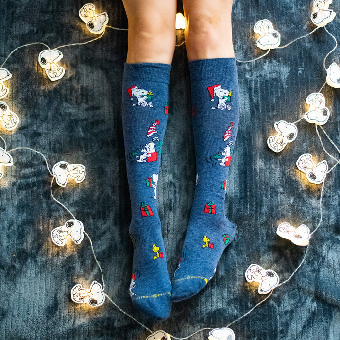 Denim heather knee-high compression socks with Peanuts presents designs, worn in a lifestyle setting.