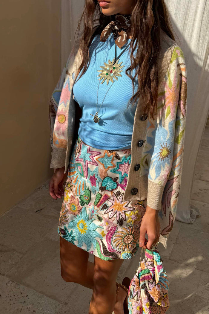 Star Beaded Dreamer Mini Skirt with hand-embroidered pastel motifs, styled with a blue top and knit cardigan.