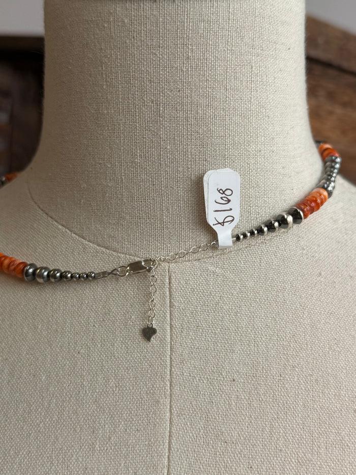 Orange spiny sterling necklace with silver clasp and small dangling charm