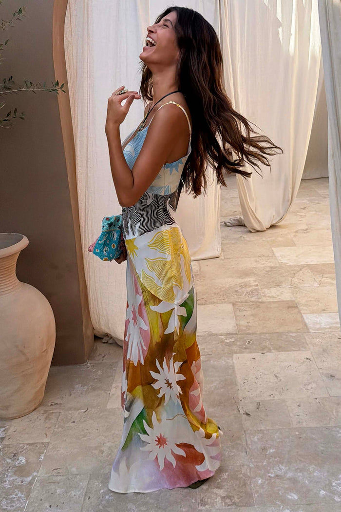 Abstract Soleil Emilia Dress in a pastel sun print with panelled floral details, shown on a smiling model.