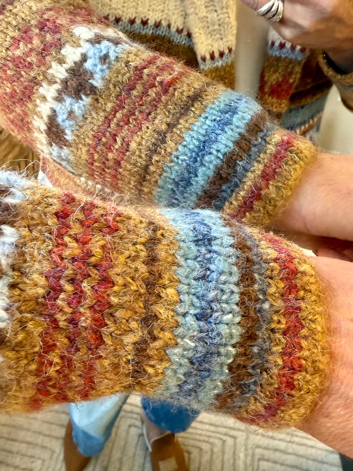 Aztec cardigan sleeve detail with multicolor striped knit and braided trim at cuff