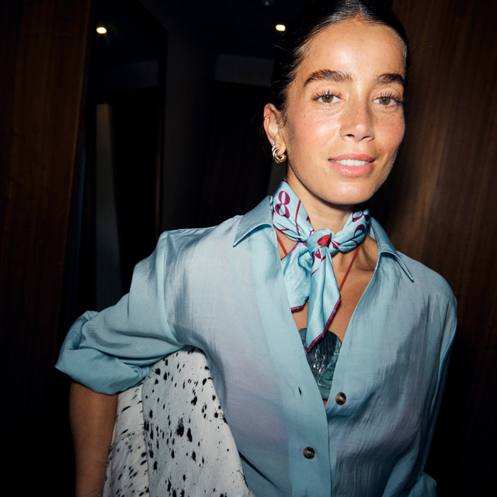 Blue and red Bingo Bandana with lips motifs, tied around the neck of a model wearing a light blue shirt.