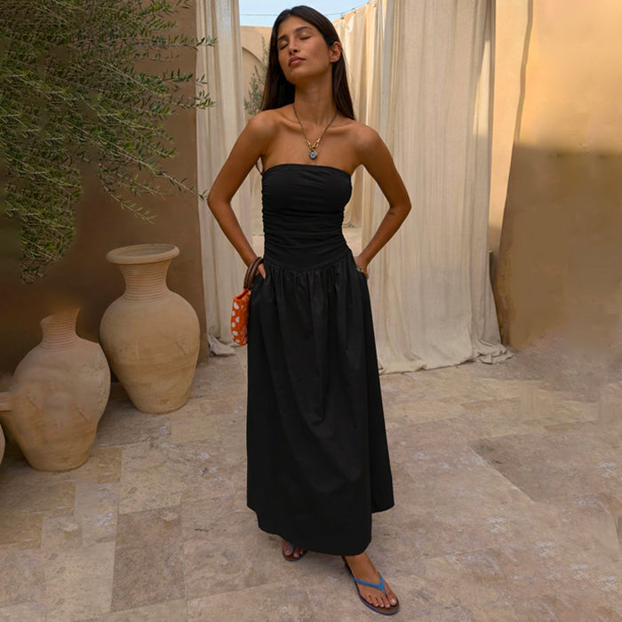 Black Lola mid-axi dress with a ruched strapless bodice and flowy cotton skirt in a rustic vacation setting.