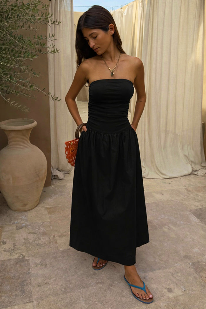 Black Lola Mid-axi Dress with a ruched bodice and flowy cotton skirt, styled for a summer vacation.