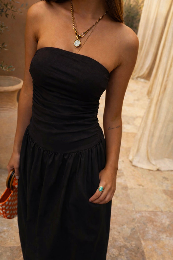Black Lola Mid-axi Dress with a strapless ruched bodice and breathable cotton skirt for a vacation look.