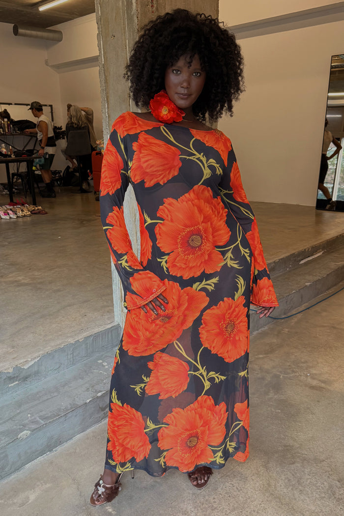 Black Poppy Aria Mesh Dress with large red poppies on sheer black fabric, worn by a model with a floral neck accessory.