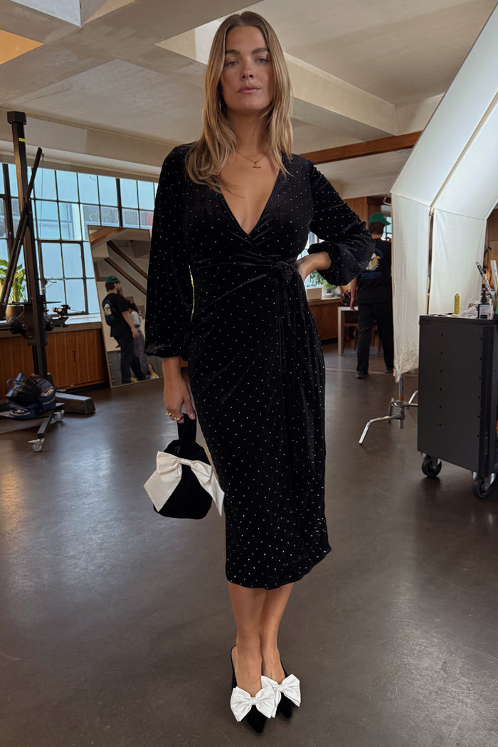 Petite black velvet midi Vienna dress with silver studs and a wrap waist, styled with white bow-detail accessories.