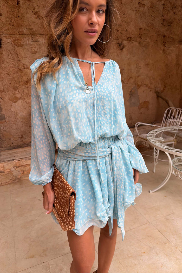Blue Fawn Ella Mini Dress with a deer print, flute sleeves and tiered ruffles, styled with a leopard clutch.