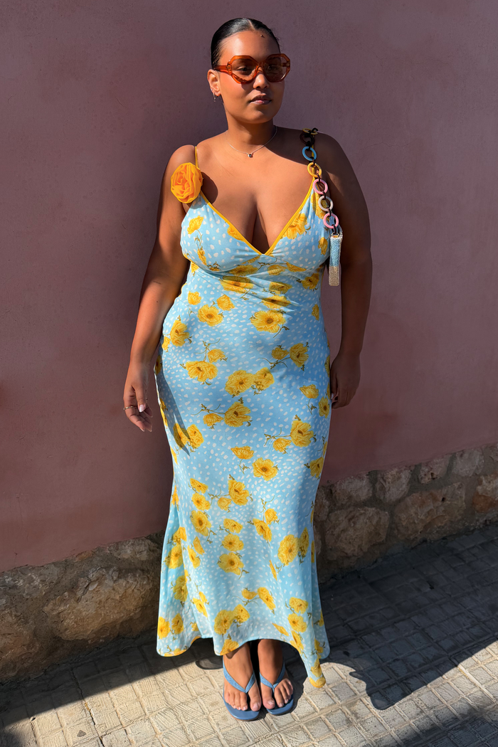 Blue Fawn Poppy Elsie slip dress with yellow poppy and fawn spot prints and a detachable flower on a model.