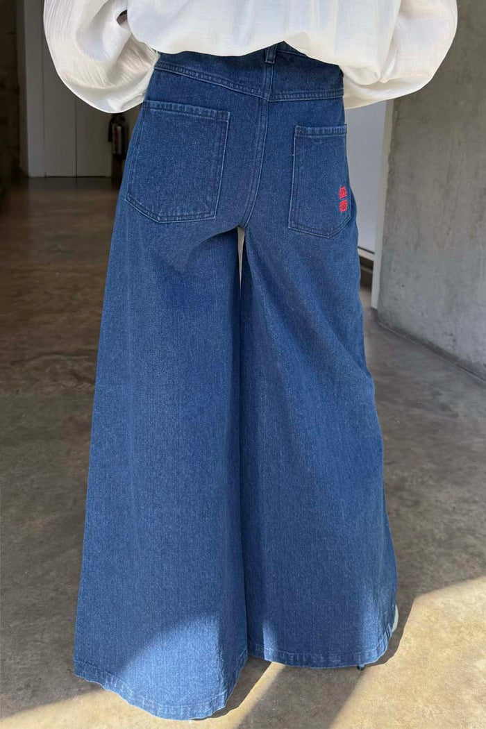 Blue Denim Pallazzo Jan Jeans featuring a wide-leg silhouette and red embroidered back pocket detail.