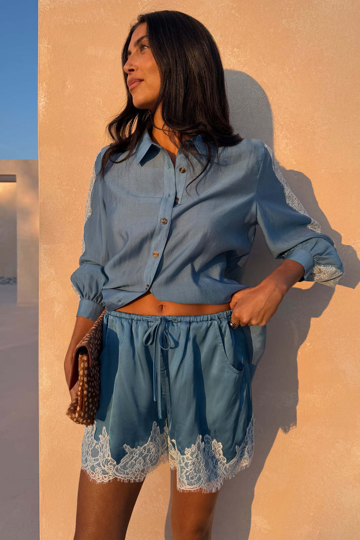 Blue Lace Maeva Shorts in washed blue satin with delicate white lace trim and drawstring waist.