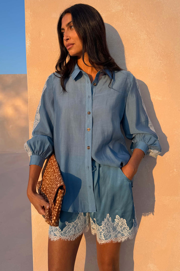 NFD Blue Lace Maeva Shorts in washed blue satin with white lace trim, paired with a matching lace-detail shirt.