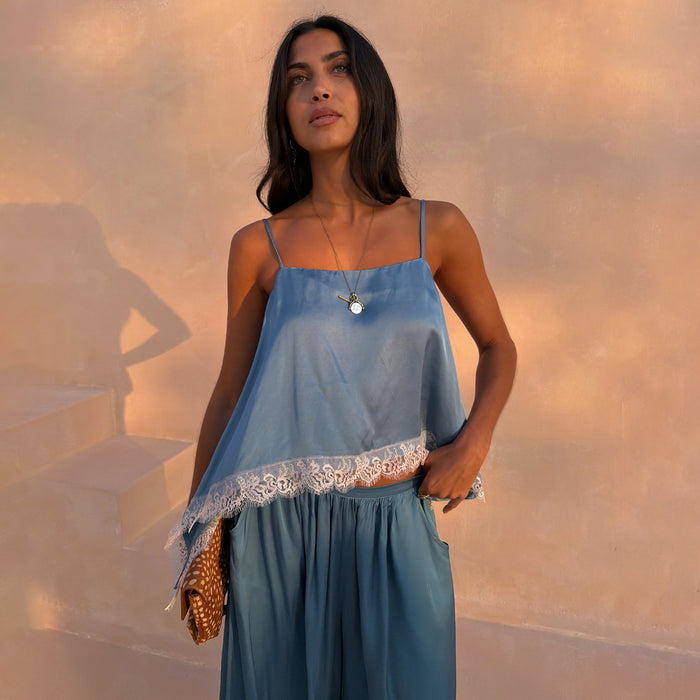 Blue Lace Swing Cami with a satin finish, fine straps and white lace trim at the hem, worn with matching trousers.