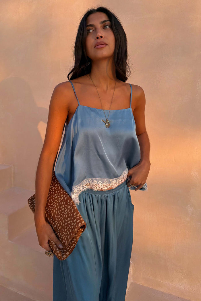 Blue Lace Swing Cami featuring a satin-feel base, thin straps, and lace-trim hem, paired with matching blue trousers.