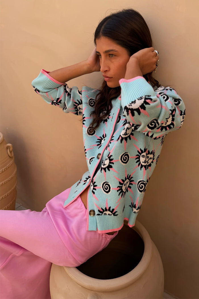 Blue Sun Hollie Cardigan in blue soft touch knit featuring pink sun prints and button-up fastening.