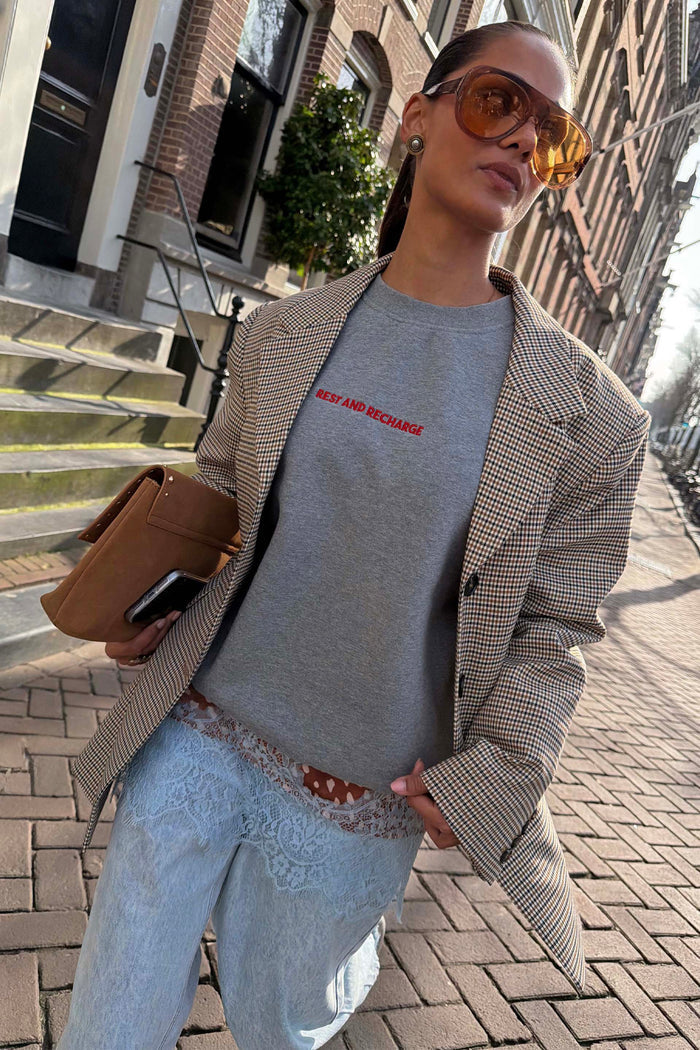 Grey Check Blazer layered over a grey sweatshirt and lace-trimmed denim for a London look.
