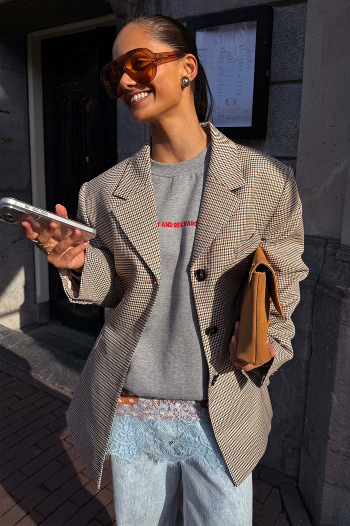 Grey Check Blazer featuring tailored darts, styled over a sweatshirt for a transeasonal London look.