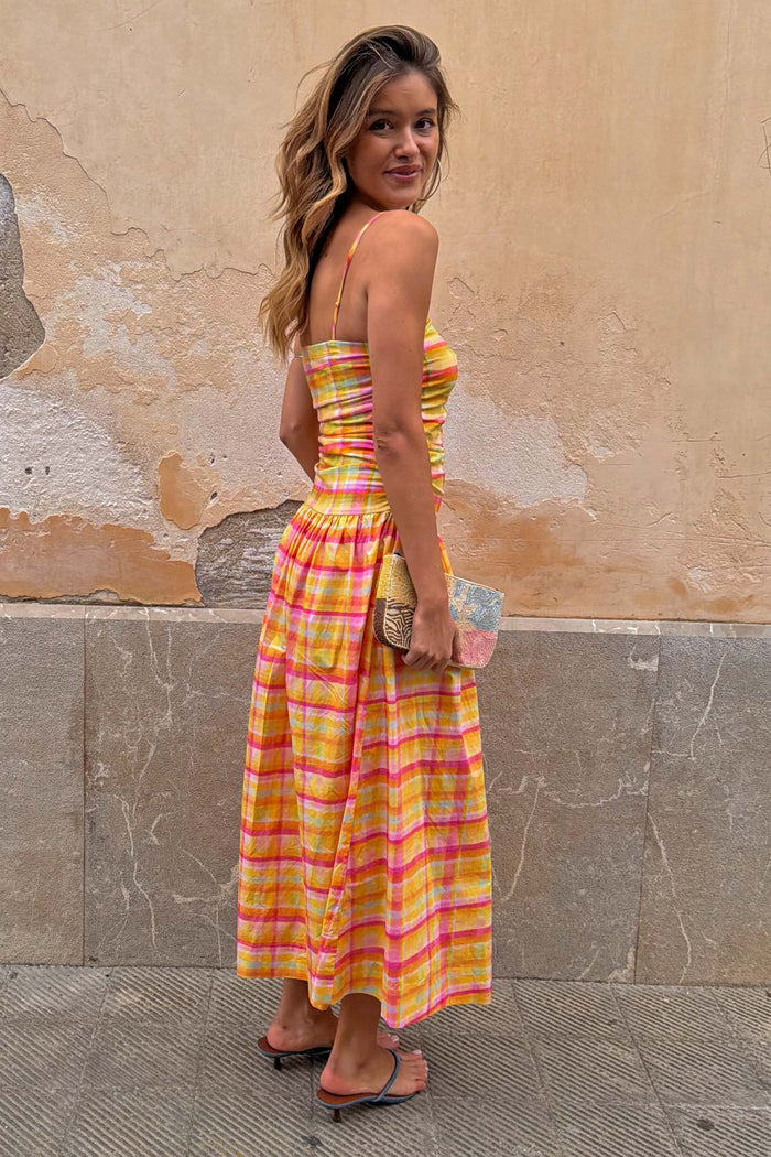 Check Lola Mid-axi Dress in yellow, pink and orange with a ruched bodice and cotton skirt, shown on a model.