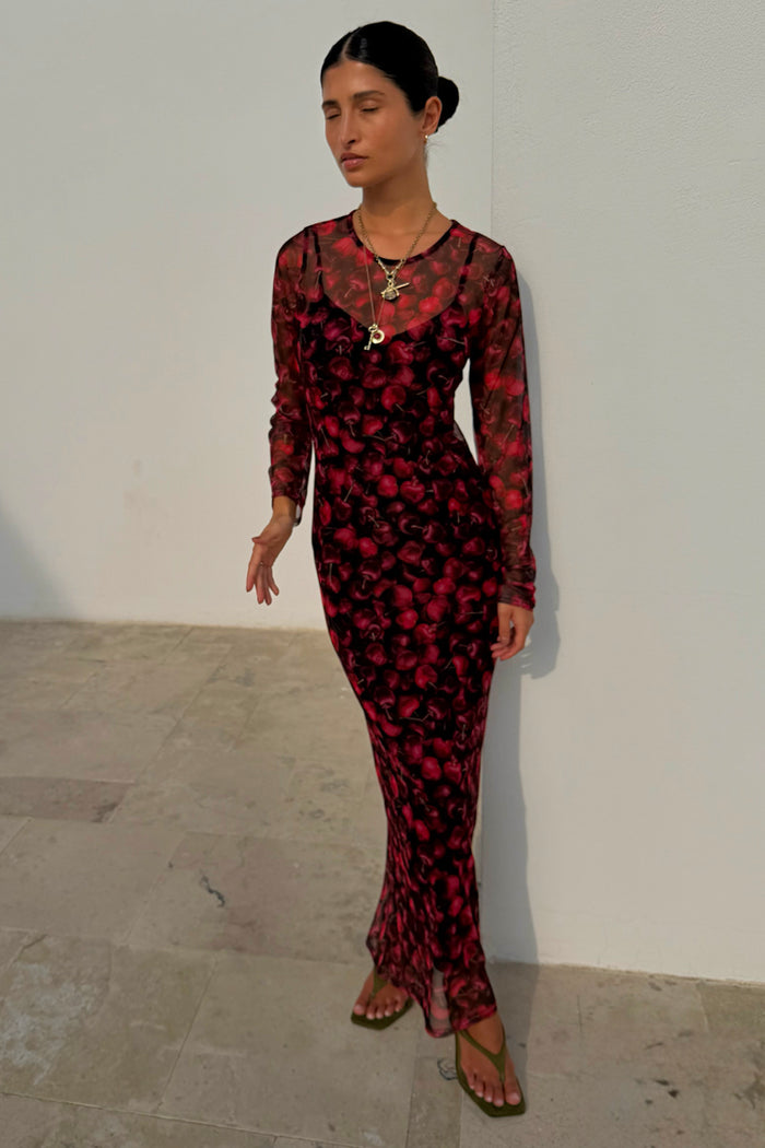Cherry Mesh Soho Dress in a red digital cherry print with long sleeves and a sheer midaxi silhouette.