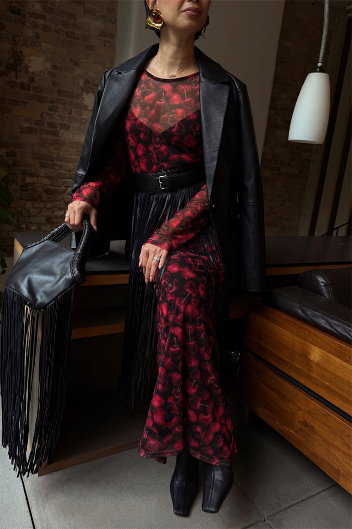 Red Cherry Mesh Soho Dress in a digital cherry print, styled with a black blazer, belt and a statement fringe bag.