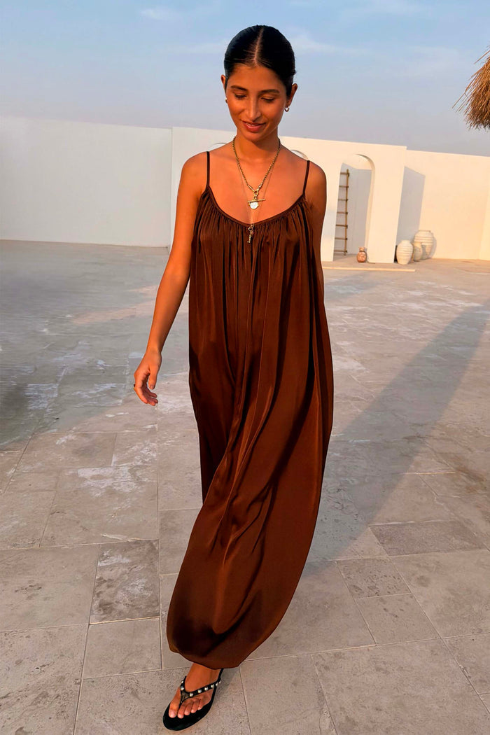 Chocolate Balloon Jumpsuit with a draped silhouette and gathered neckline, shown on a model outdoors.