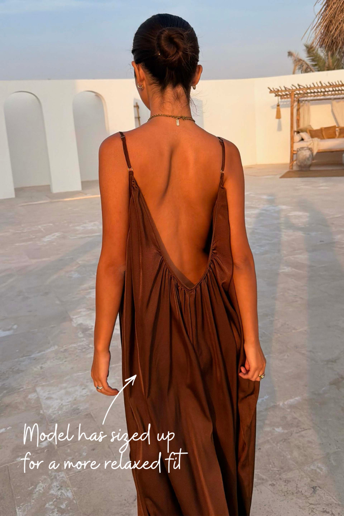 Chocolate Balloon Jumpsuit featuring a deep V-back and slim straps, shown in a relaxed fit on a model.