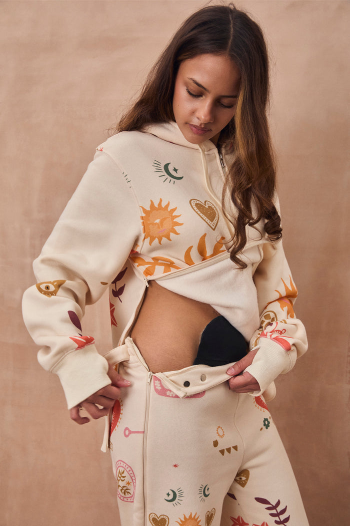 Cream Sundazed Accessible Joggers with NFD motifs, featuring side zips designed for medical treatment access.
