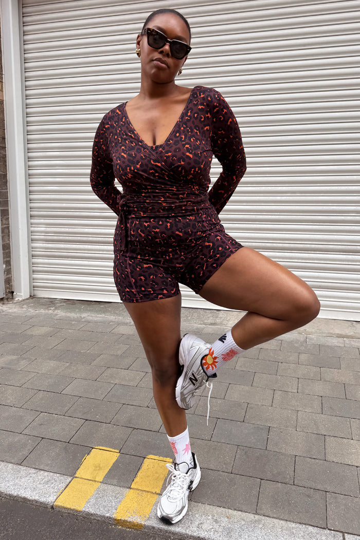 Dark Leopard Ballet Wrap with orange accents and flared sleeves, styled with matching shorts and white trainers.