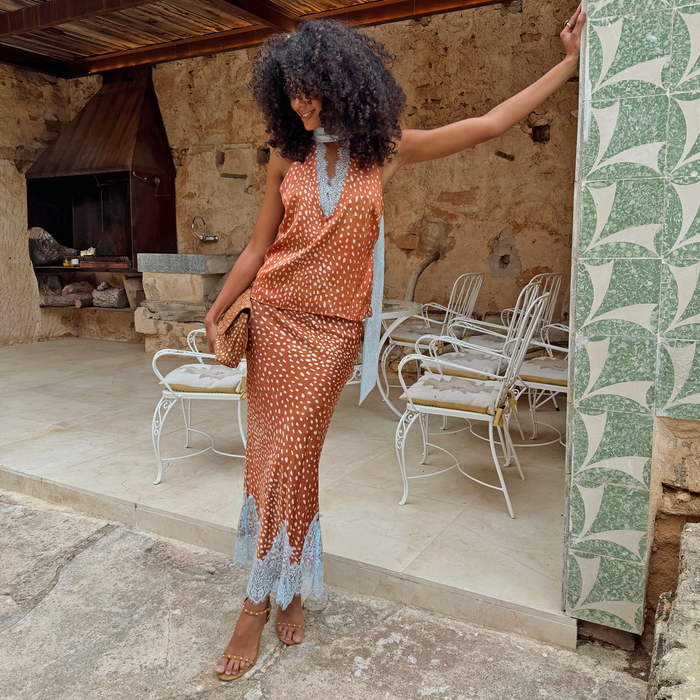 Brown Fawn Midi Maeva Skirt with light blue lace trim, styled as a co-ord in a rustic outdoor courtyard.