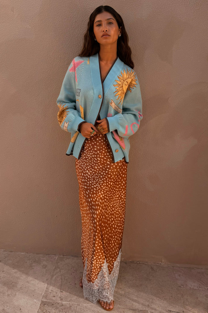 Fawn print Maeva midi skirt with a brown base and white lace trim, styled with a light blue graphic cardigan.