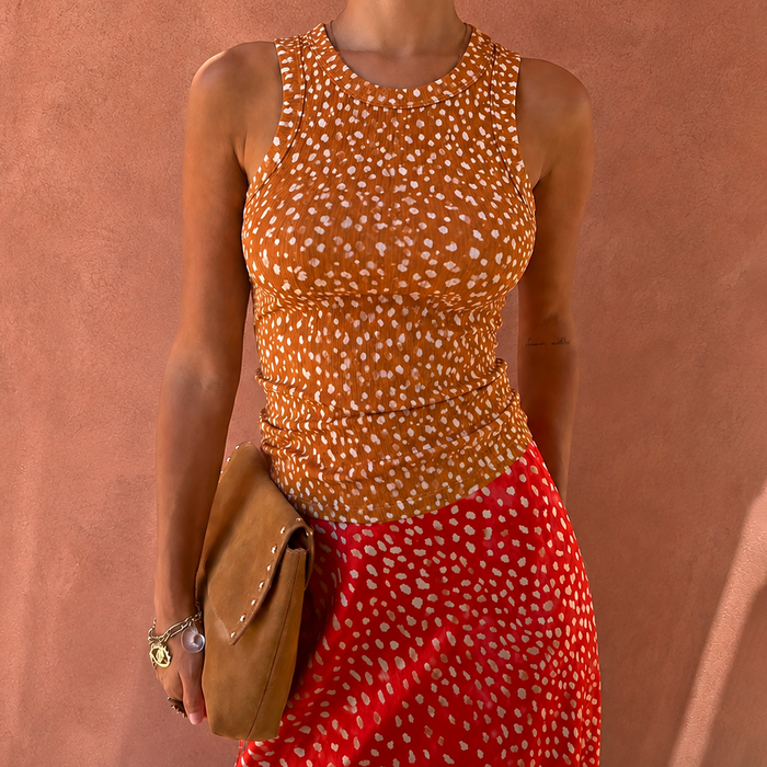 Fawn Rib Tank Top featuring an orange and white speckled print and high neck, styled with a red patterned skirt.