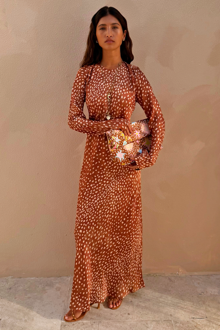 Fawn Soho Maxi Dress in brown satin-esque fabric with a cream deer print and flared sleeves on a model.