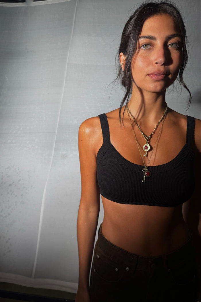 Deloris Key Necklace with a red gemstone and brass link chain, layered on a model for multi-wear London looks.
