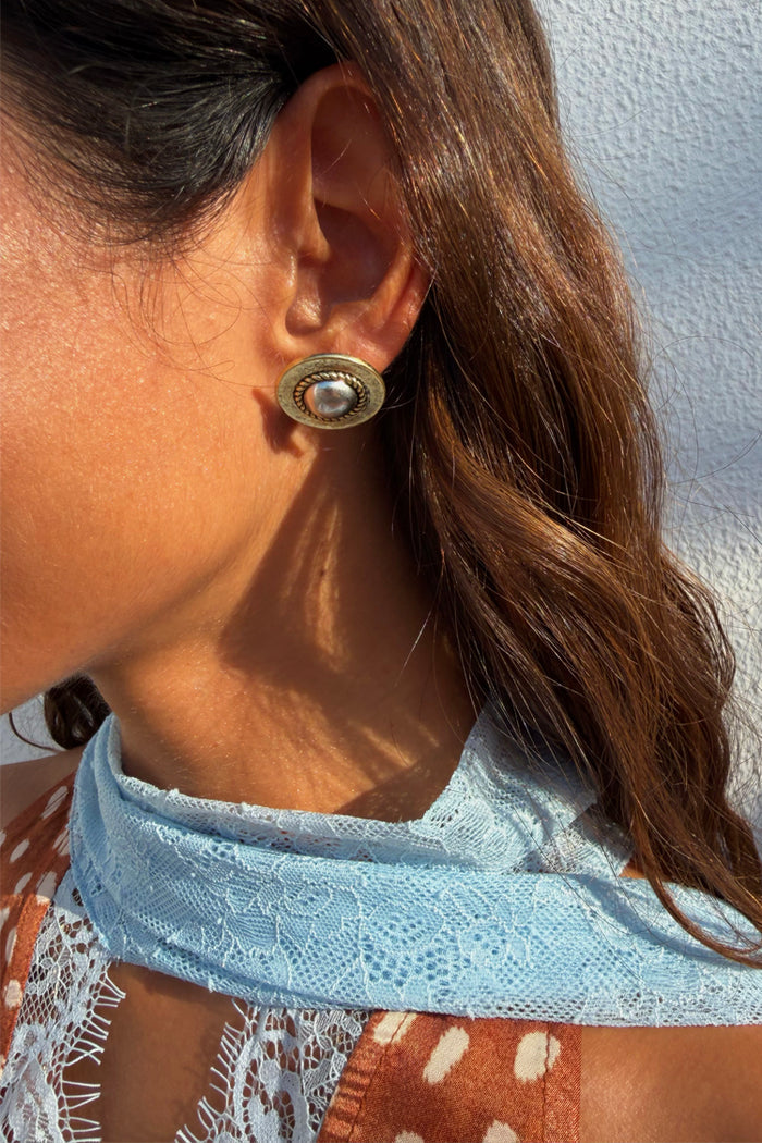 Deloris Silver Circle Earrings in textured brushed metal with vintage vibes, worn by a model with a blue lace scarf.