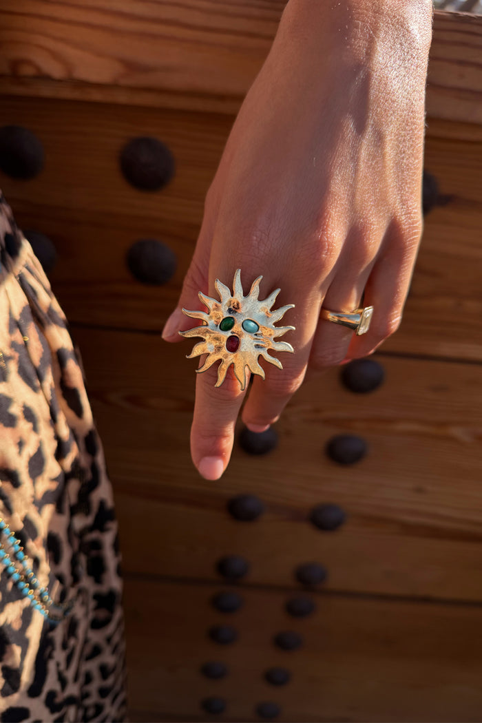Deloris Sun Ring in brass with semi-precious stones and an iconic sun motif, styled with leopard print.