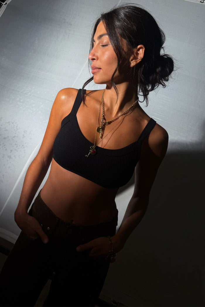 Deloris Thin Chain Key Necklace featuring a gold key charm and red gem, worn with a black crop top.