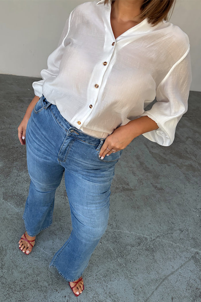 Blue Denim Flare Scallop Jean with 70s-style flared cuffs and scalloped pockets, shown on a size 18 model.