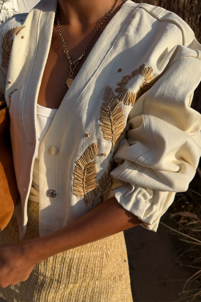 Ecru Cove Raffia Denim Jacket featuring textured palm embroidery, branded metal buttons and elasticated cuffs.