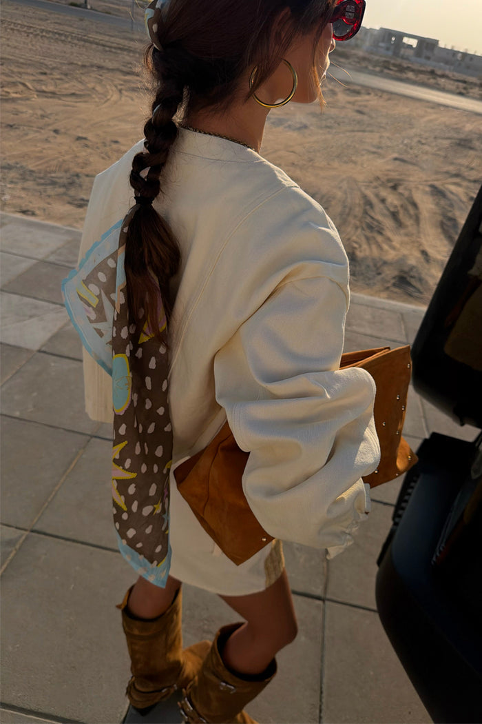 Ecru Cove Raffia Denim Jacket with palm embroidery and elasticated cuffs, styled with a patterned hair scarf.