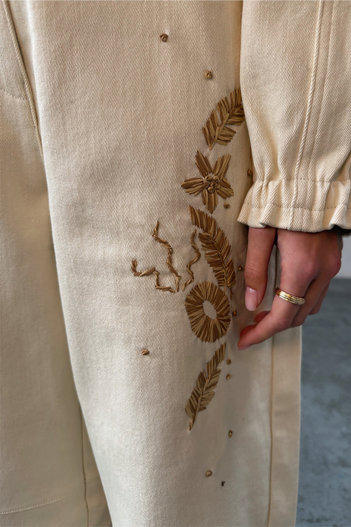 Ecru Palma Barrel Leg Jeans featuring textured brown raffia floral and palm embroidery on cream denim.