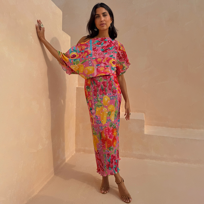 Pink Fruit Tilly Dress with metallic flecks and lemon print, featuring a draped off-shoulder top and pleated skirt.
