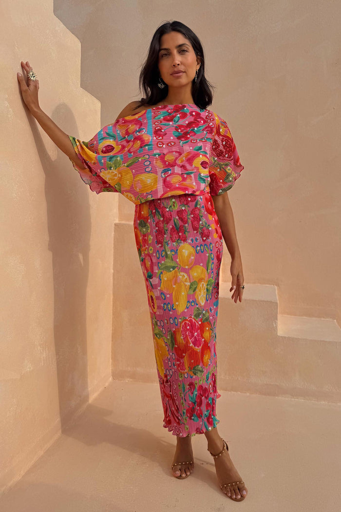 Pink Fruit Tilly Dress with a citrus print, off-shoulder top and pleated metallic fleck midaxi skirt.