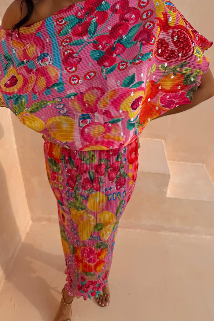 Pink Fruit Tilly Dress with metallic flecks, a vibrant citrus print, and textured pleating on a fitted midaxi skirt.