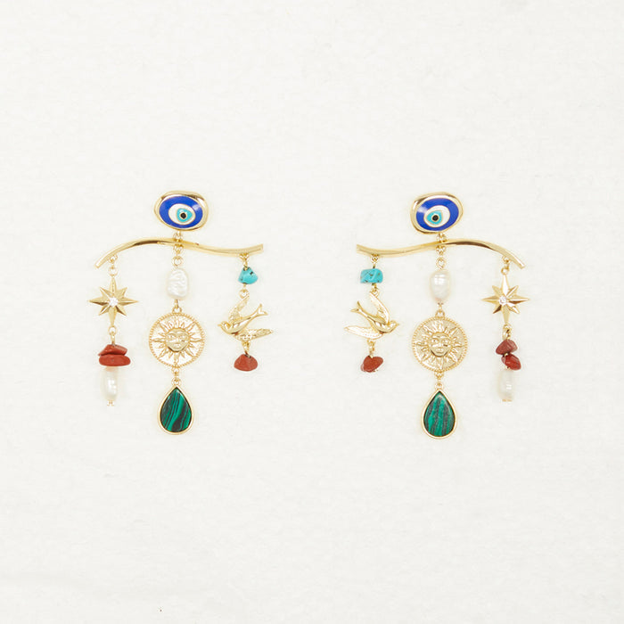 Gold Plated Balearic Charm Earrings featuring turquoise eye motifs, sun charms, and pearls on a neutral background.