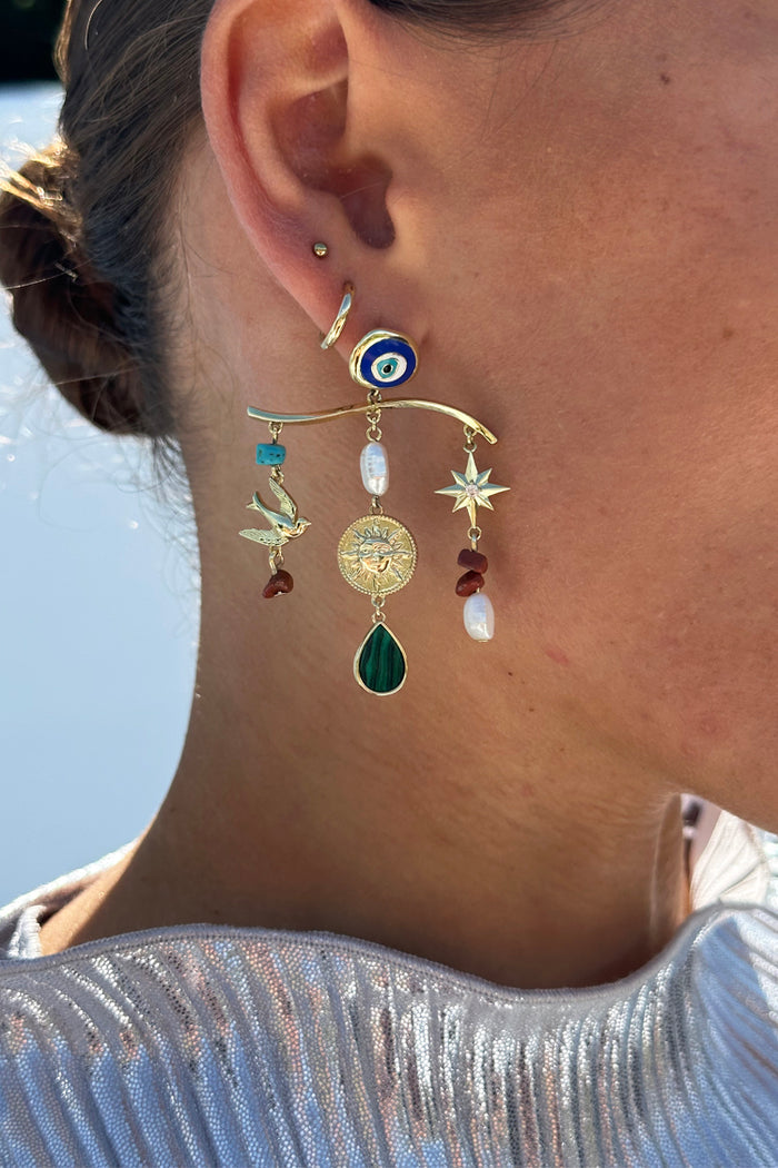 Gold Plated Balearic Charm Earring with turquoise, pearls and iconic motifs, styled on a model's ear.