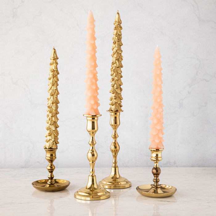 A set of two pink unscented tree-shaped taper candles, with one candle longer than the other, displayed on a surface with a decorative, antique-style gold candle holder.